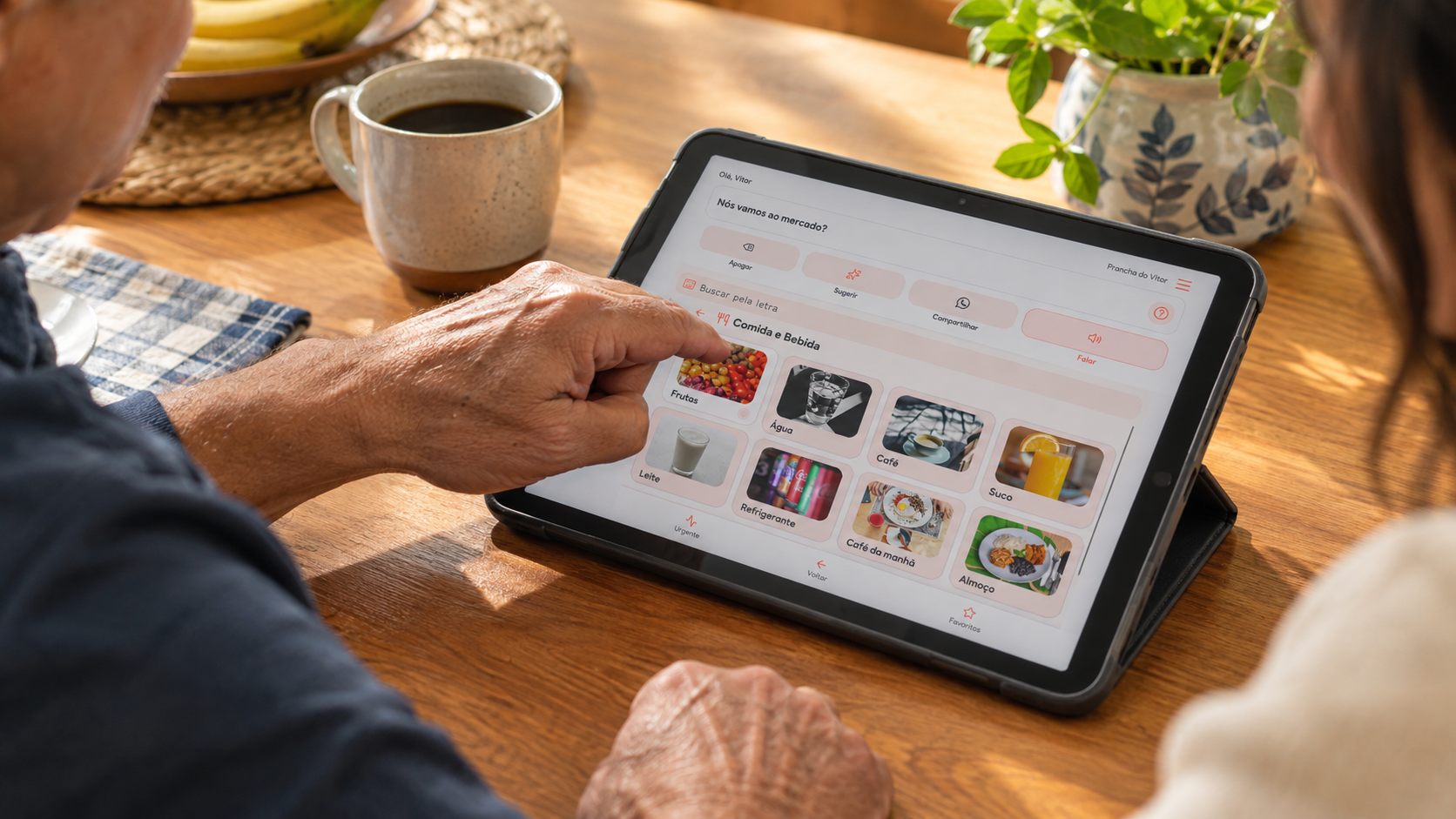 Casal de idosos usando um tablet juntos à mesa, explorando recursos de comunicação